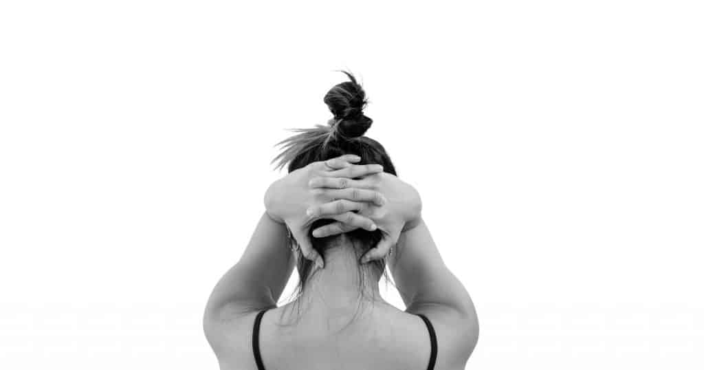 rear view of womans head holding hands behind head